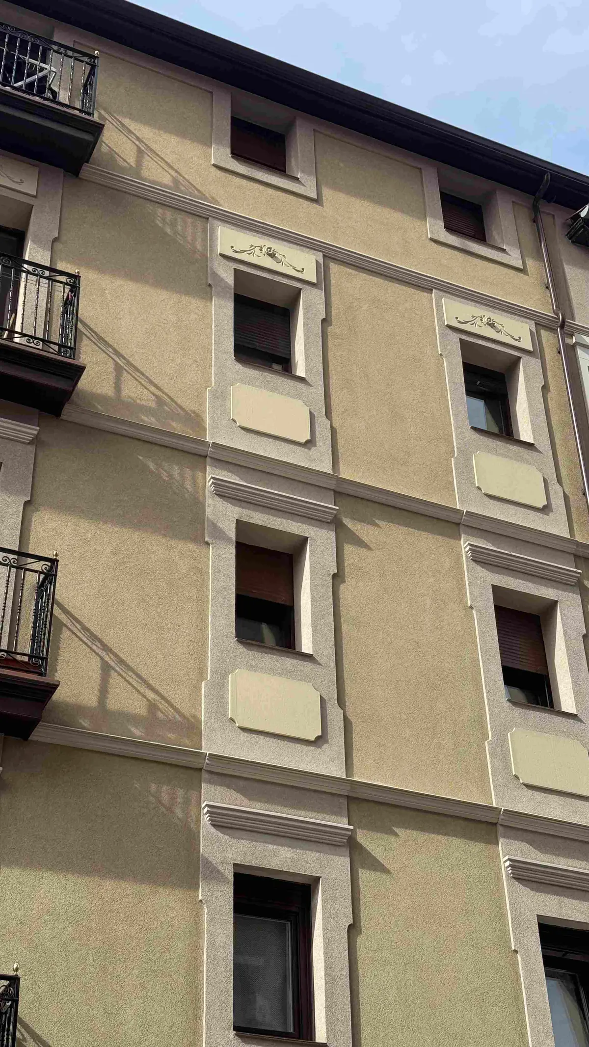 Detalle vertical de la fachada rehabilitada con recercados de ventanas