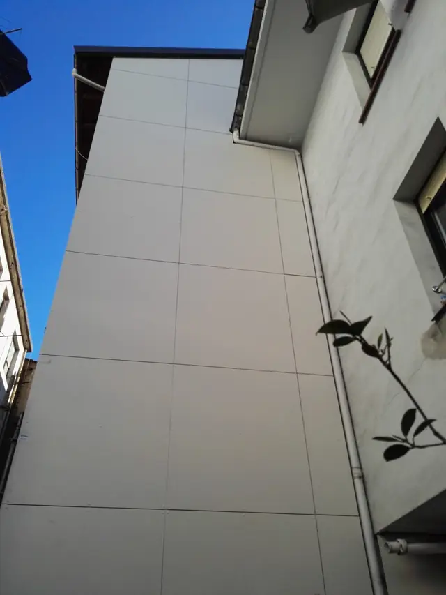 Medianera revestida con fachada ventilada de placa fenólica clara en Durango
